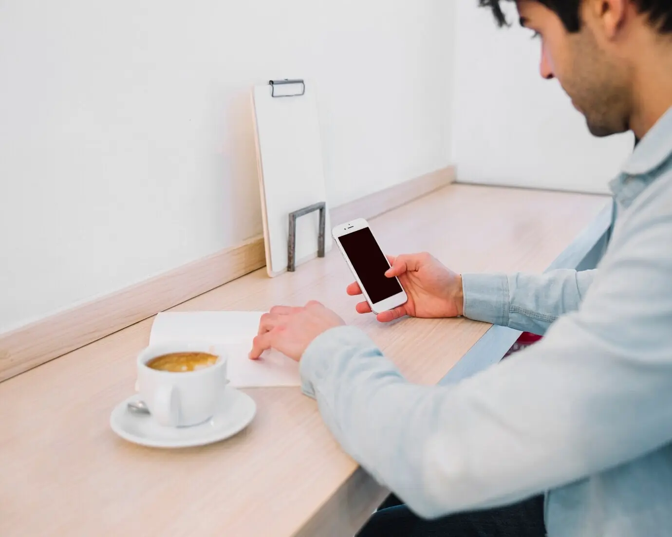 Cropped image of a man working with papers and a smartphone.